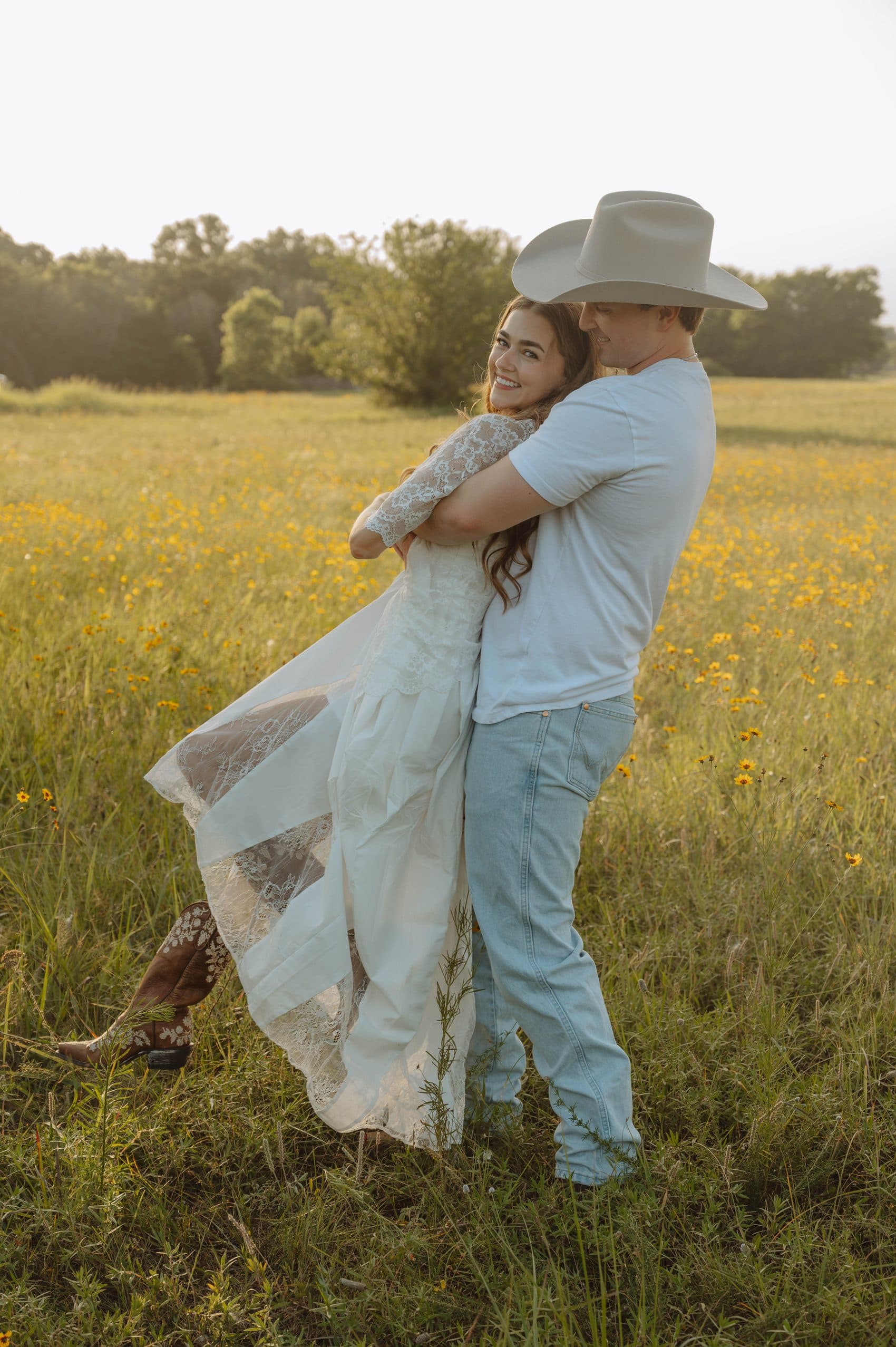 Tyler lifting Elise in a field of wildflowers