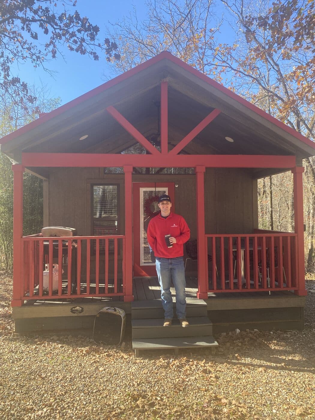 The red cabin in the woods, with Tyler on the porch